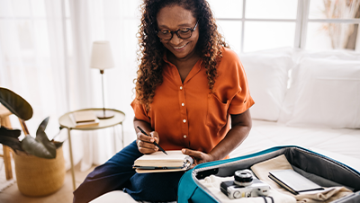 smiling woman standing in airport with passport in her hand