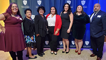 seven members of the Latino Alumni Affiliate standing in front of the UToleod backdrop at the Homecoming Gala